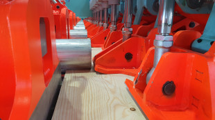 Roller conveyor for positioning is equipped with servo-controlled drives